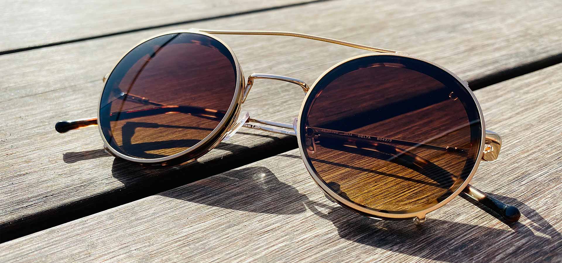 Brille mit Sonnenclip auf Holztisch